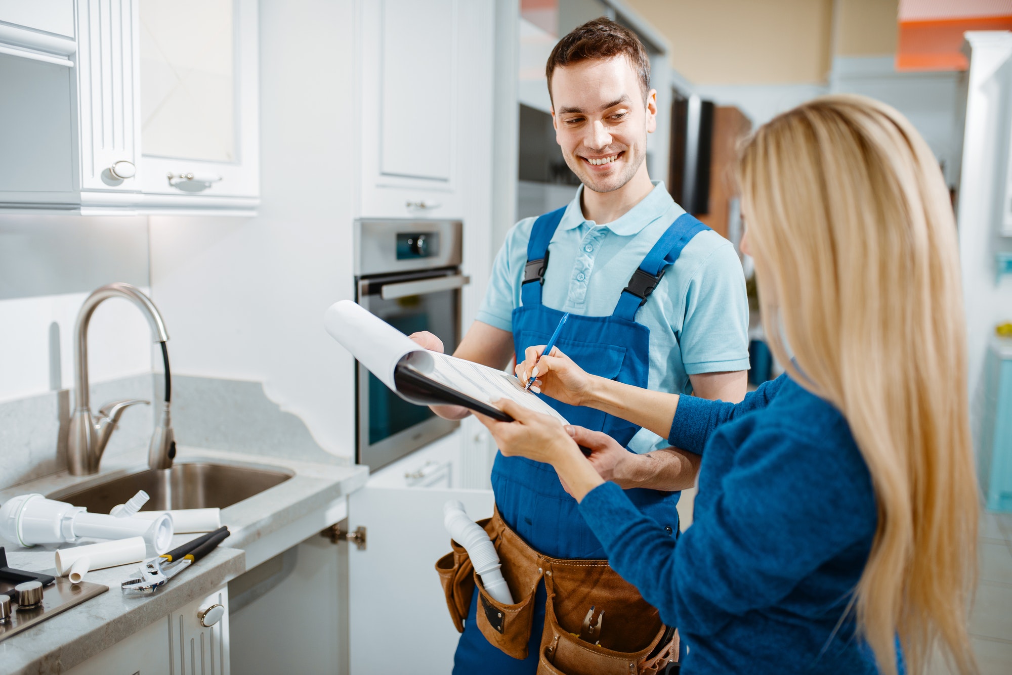 get a free estimate today, male plumber and female customer in the kitchen in NJ