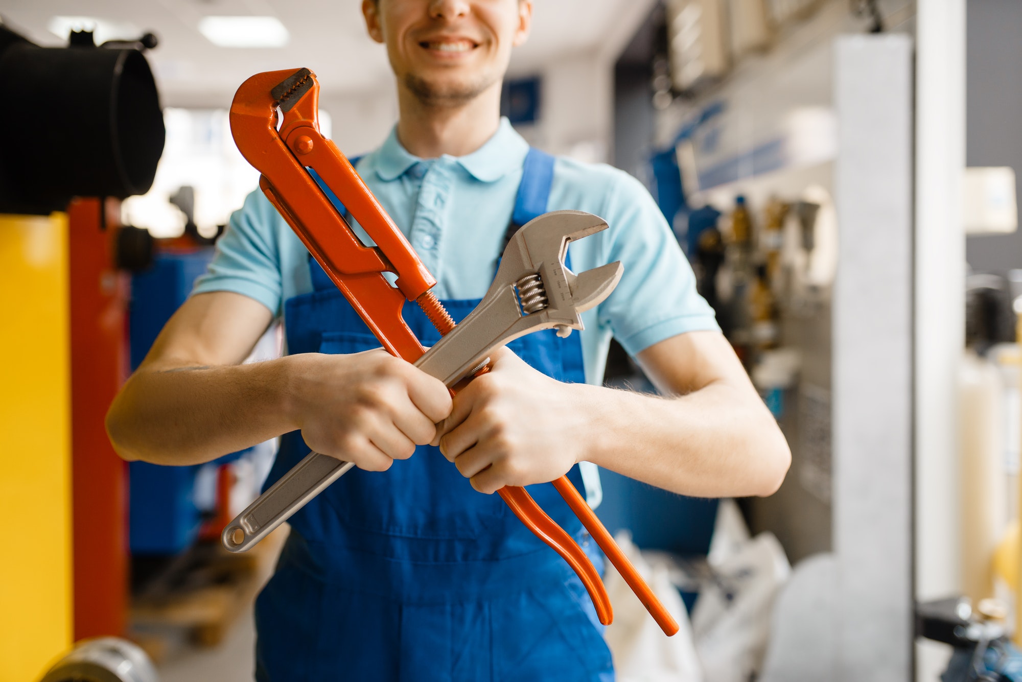 free estimates, plumber poses with pipe wrenches