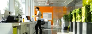 a modern, sleek office environment features a technician energetically demonstrating an innovative, eco-friendly drain cleaning solution, surrounded by high-tech equipment and vibrant promotional materials emphasizing sustainable practices.